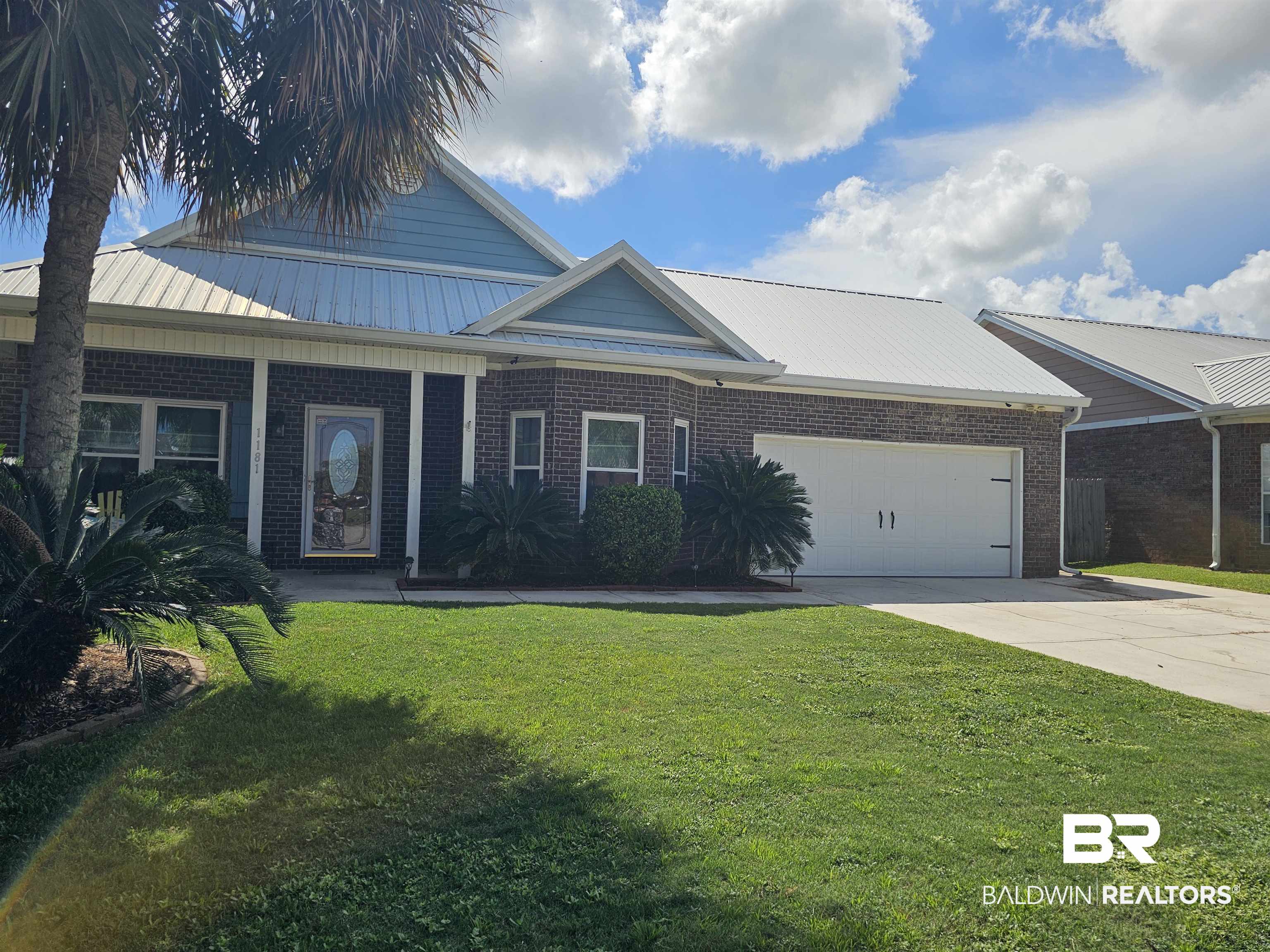 1181 Sloane Cove Foley, AL 36535 - Photo 9 of 10 Brick exterior with light blue siding accents and a white metal roof
