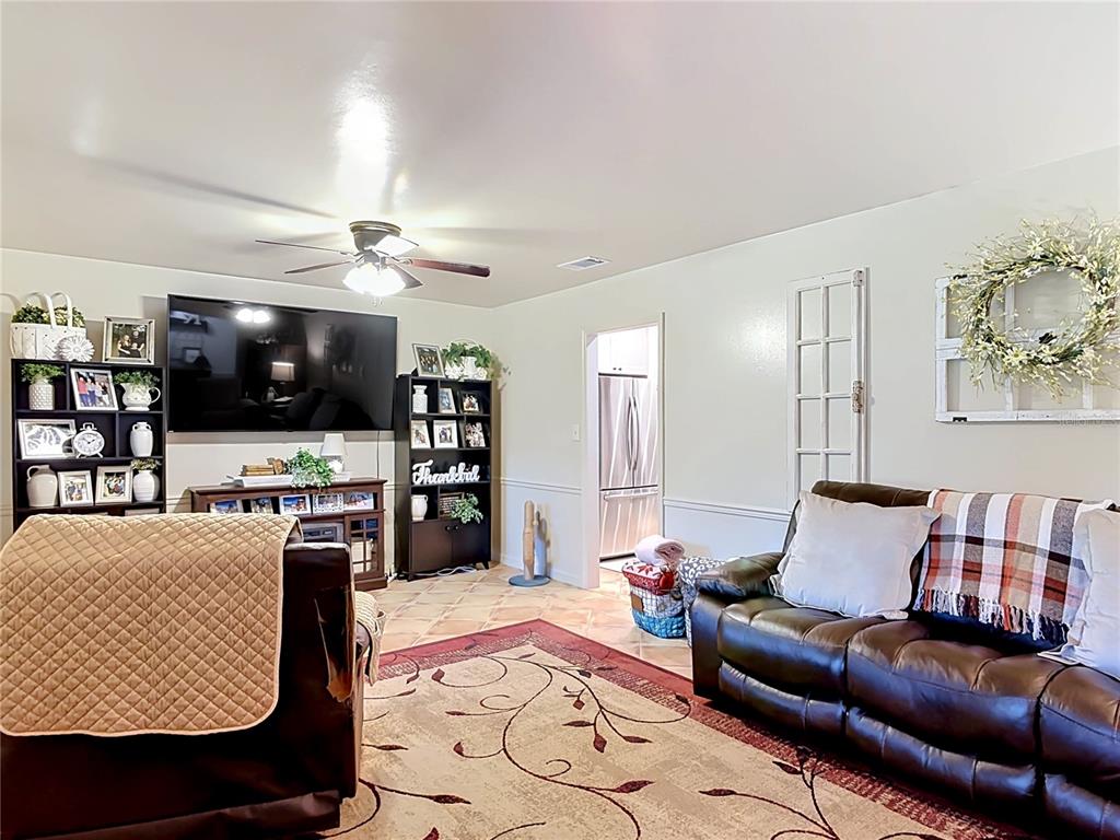 1395 Maytown Road Osteen, FL 32764 - Photo 13 of 65 a living room with furniture and a flat screen tv