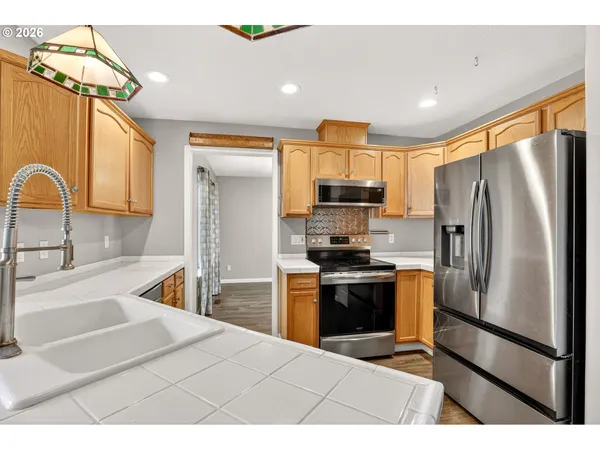 a kitchen with stainless steel appliances a refrigerator sink and cabinets