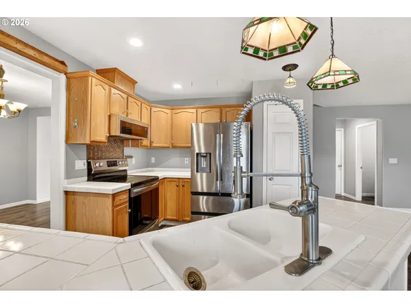 a kitchen with stainless steel appliances granite countertop a sink a stove and refrigerator