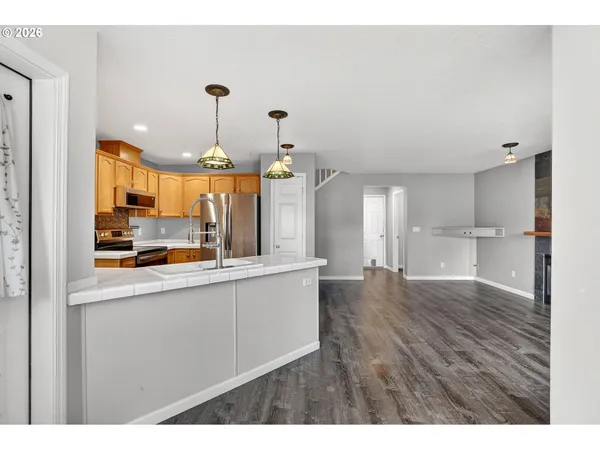 a kitchen with stainless steel appliances granite countertop a sink a stove and a refrigerator