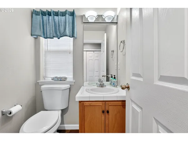 a bathroom with a sink toilet mirror and vanity