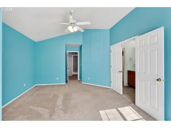 a view of an empty room with chandelier fan