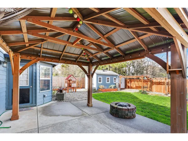 a view of a yard in front of a house with a large tree