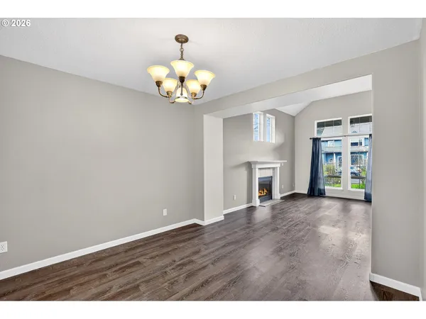 a view of an empty room with a fireplace and a window