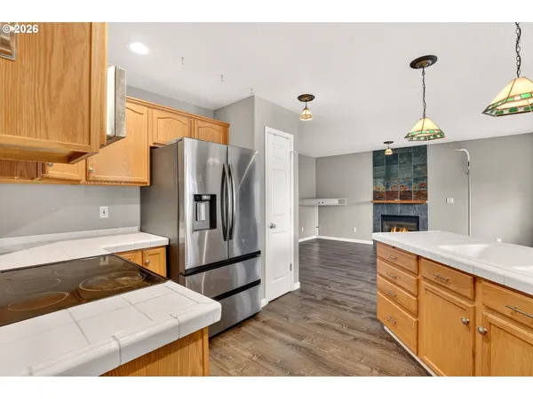 a kitchen with stainless steel appliances kitchen island granite countertop a refrigerator and a sink