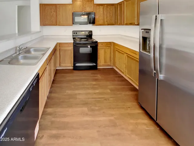a kitchen with kitchen island granite countertop a sink stainless steel appliances and cabinets