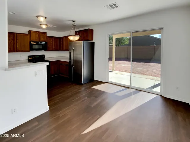 a open kitchen with granite countertop a refrigerator and a stove top oven