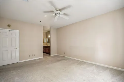 an empty room with fan and windows