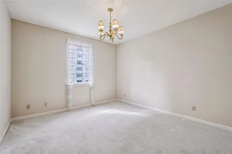 an empty room with windows and chandelier