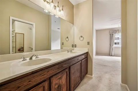a bathroom with a granite countertop double vanity and a mirror