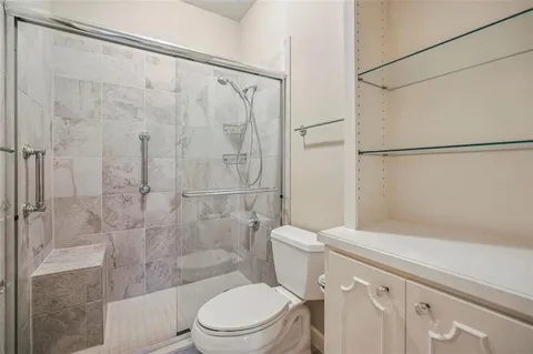 a white toilet sitting next to a bath tub and a shower