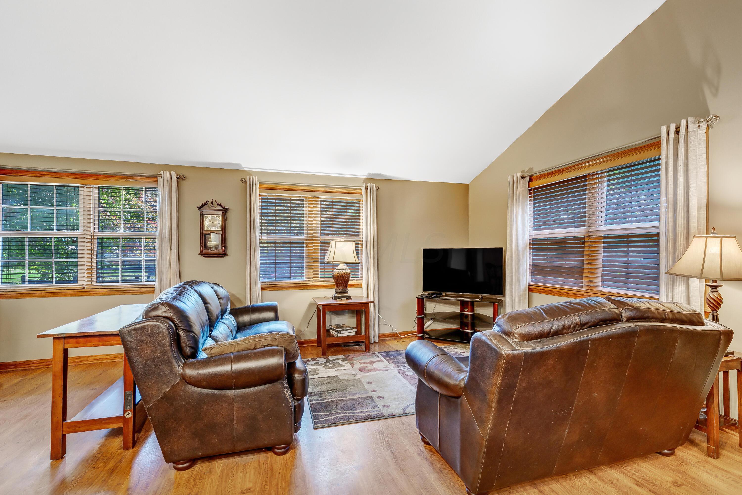 6681 Harlem Road Westerville, OH 43082 - Photo 14 of 78 • Laminate flooring • Tan painted walls • Vaulted ceiling • 2” blinds remain • Door to rear deck