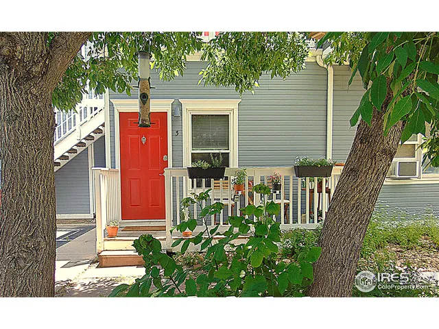 an empty room with wooden floor closet and windows
