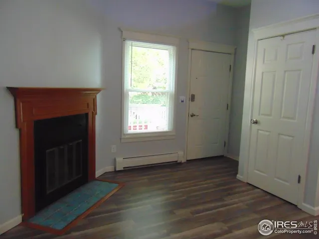 a view of a livingroom with a fireplace and wooden floor