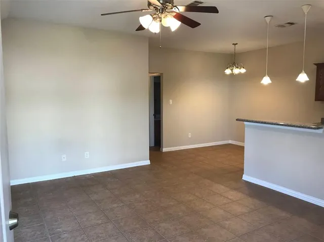 an empty room with a ceiling fan and window