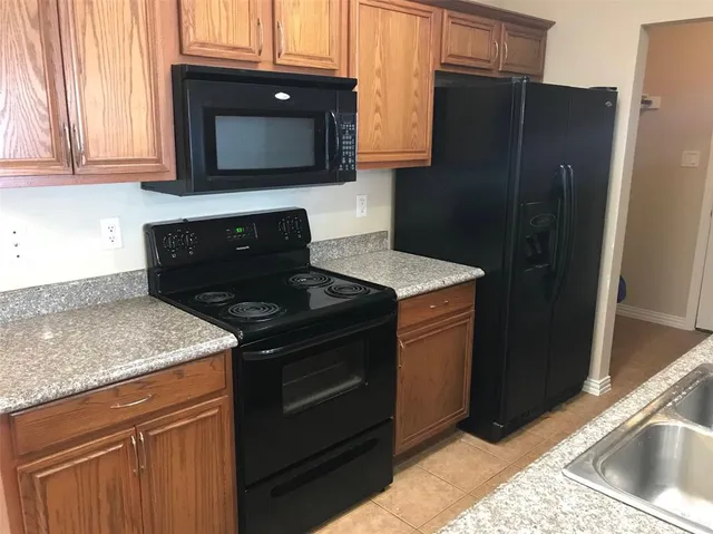a kitchen with stainless steel appliances granite countertop a refrigerator stove and sink