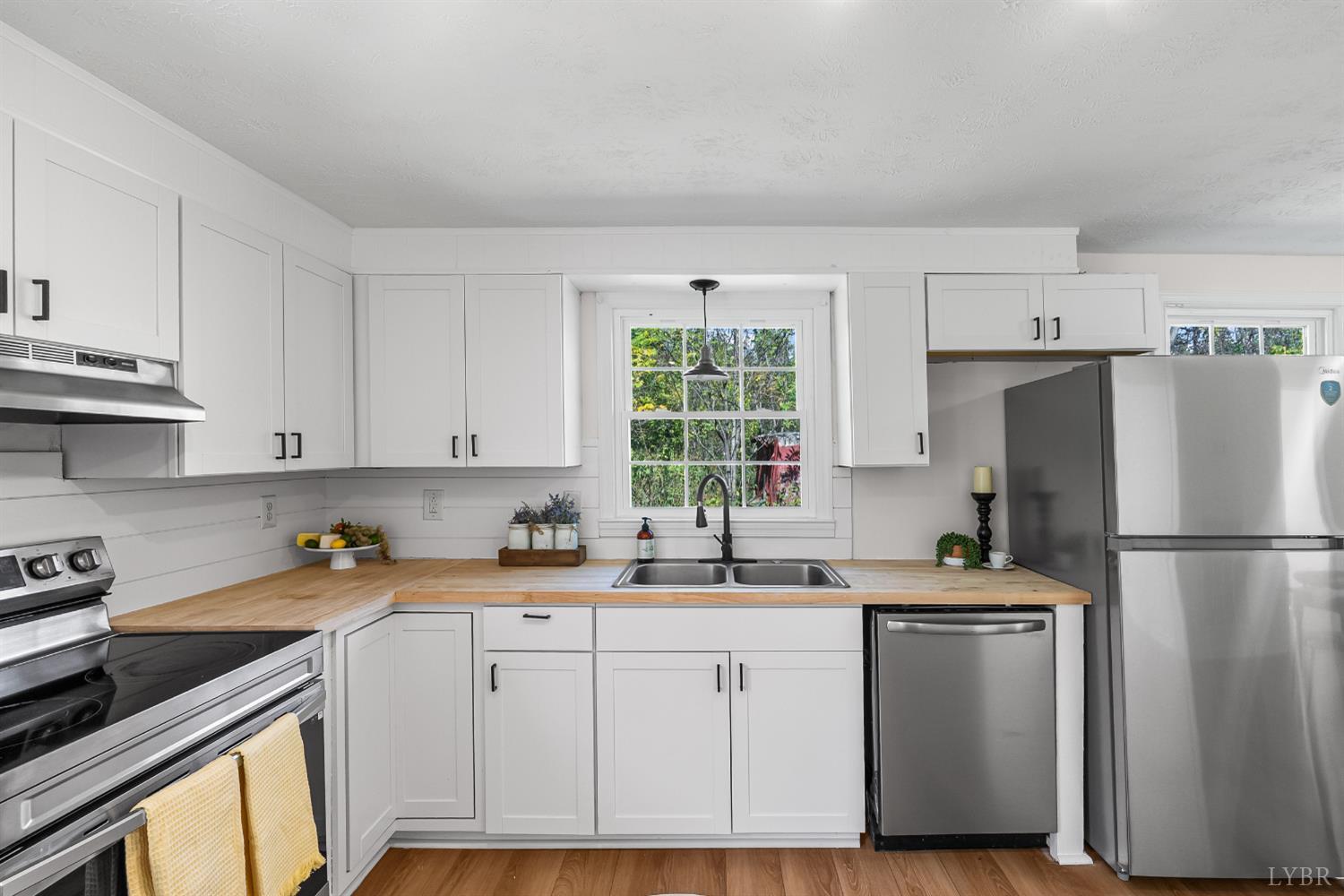 202 Ridgecrest Drive Monroe, VA 24574 - Photo 9 of 25 a kitchen with a refrigerator a sink cabinets and a window