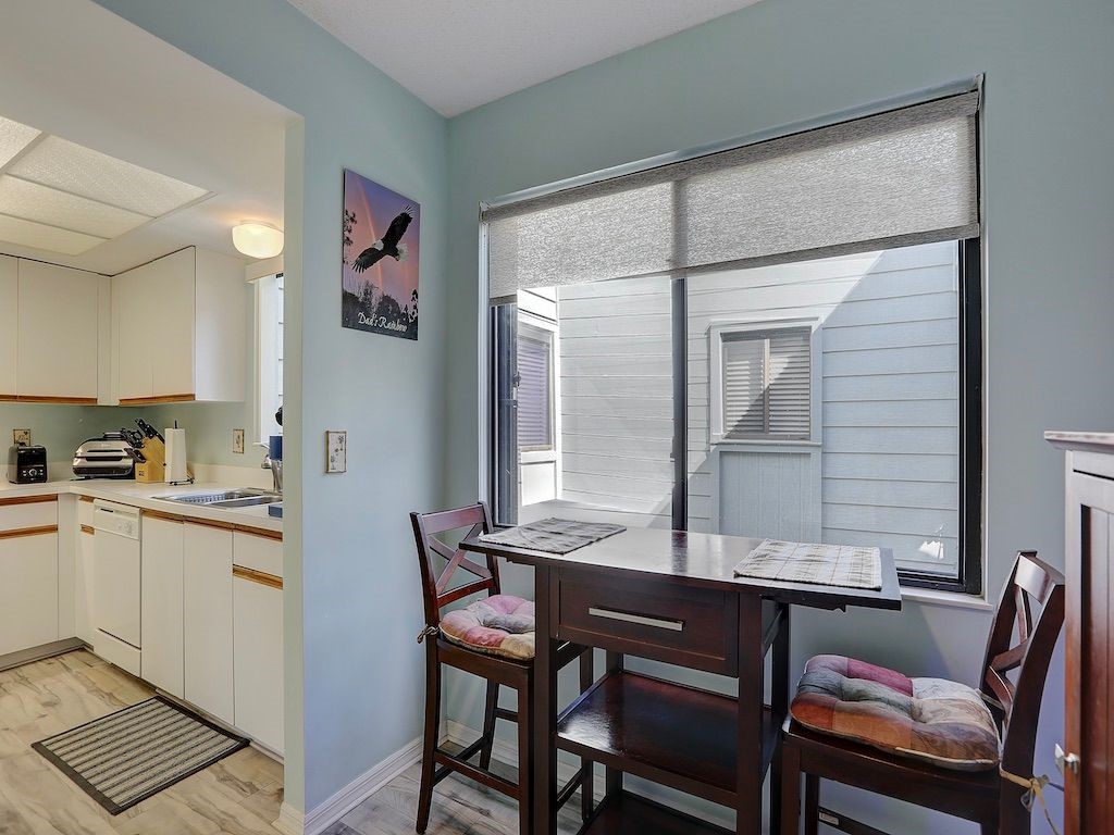 2150 Pine Creek Boulevard, Unit 202 Vero Beach, FL 32966 - Photo 11 of 31 a kitchen with a table and chairs