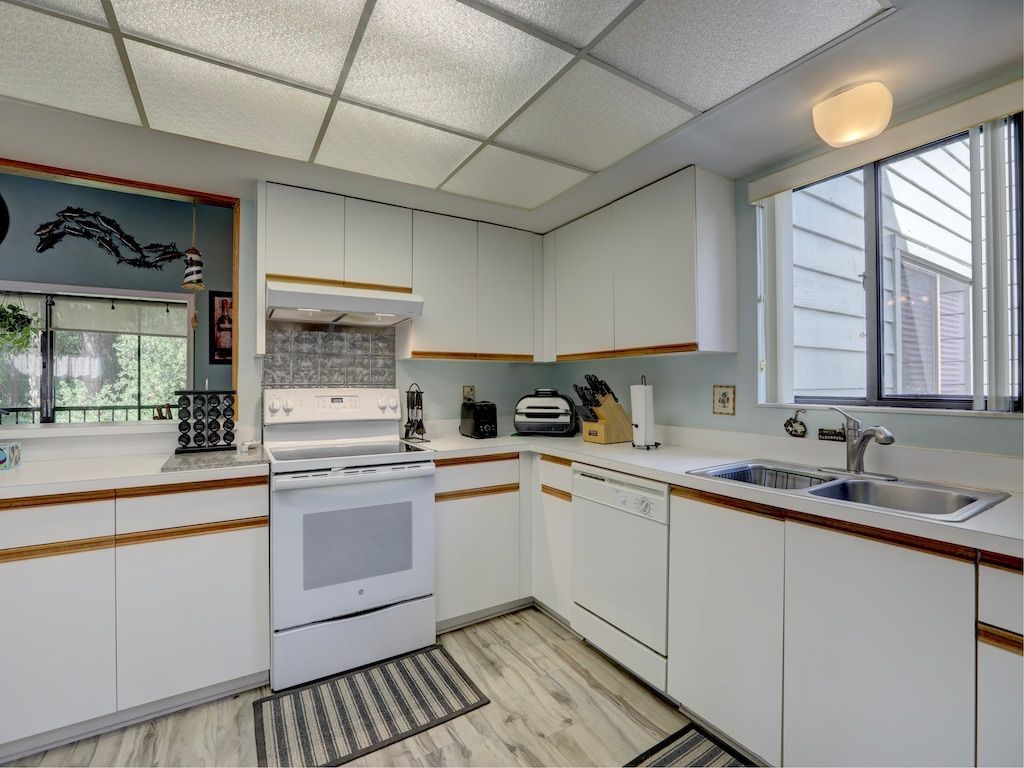 2150 Pine Creek Boulevard, Unit 202 Vero Beach, FL 32966 - Photo 12 of 31 a kitchen with a sink stove and cabinets