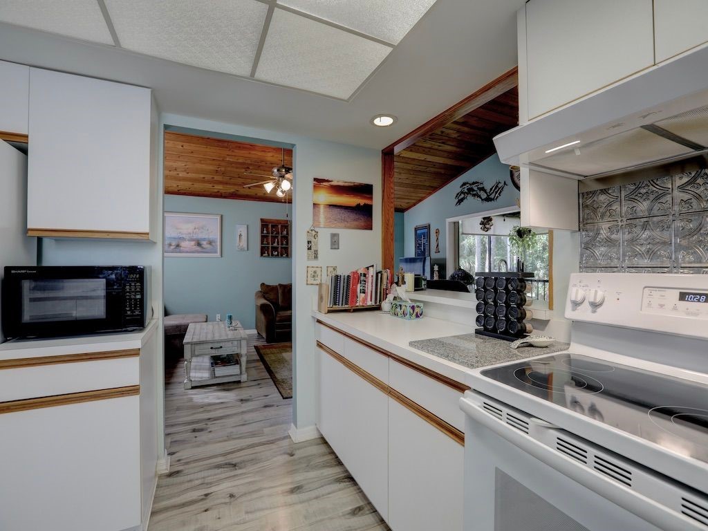 2150 Pine Creek Boulevard, Unit 202 Vero Beach, FL 32966 - Photo 14 of 31 a kitchen with stainless steel appliances a sink a stove and cabinets