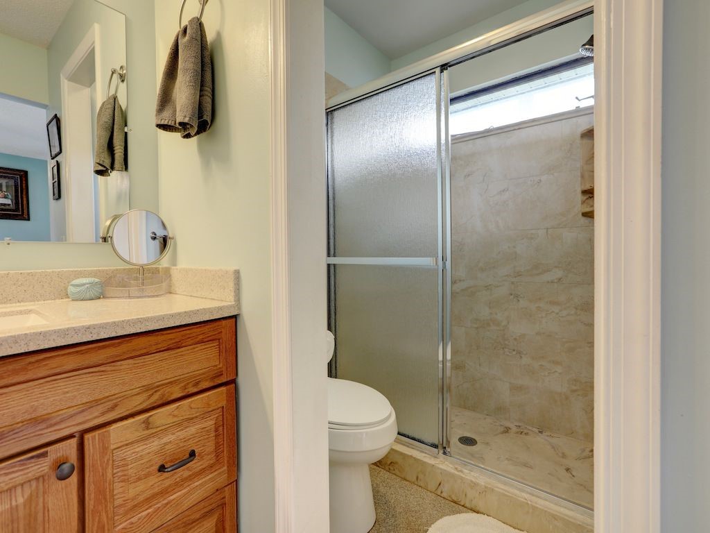 2150 Pine Creek Boulevard, Unit 202 Vero Beach, FL 32966 - Photo 19 of 31 a bathroom with a granite countertop sink toilet and shower