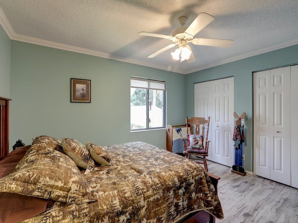 2150 Pine Creek Boulevard, Unit 202 Vero Beach, FL 32966 - Photo 20 of 31 a bedroom with a bed and a chandelier