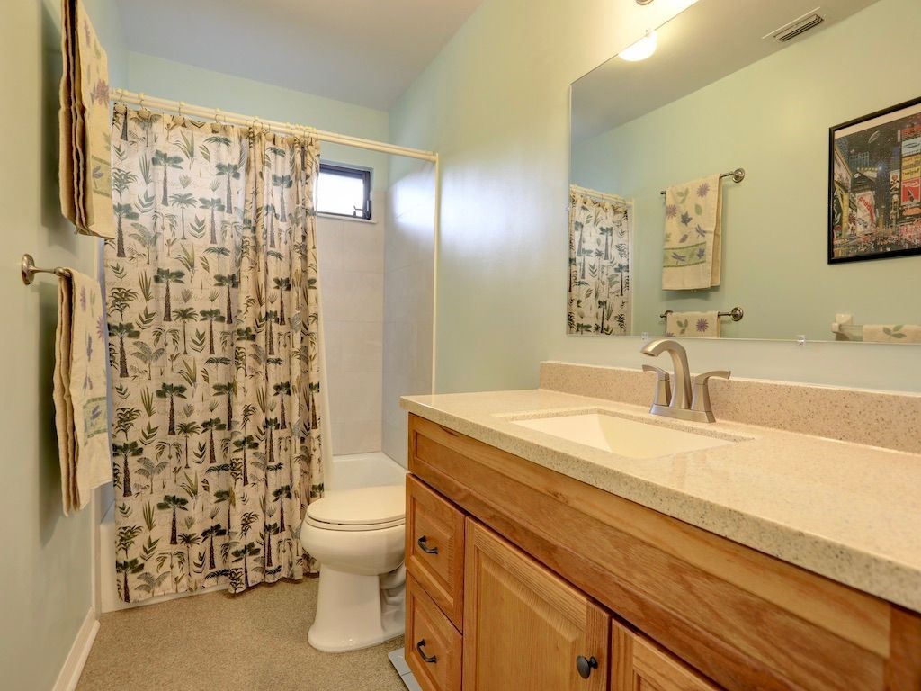 2150 Pine Creek Boulevard, Unit 202 Vero Beach, FL 32966 - Photo 22 of 31 a bathroom with a sink a toilet and shower curtain