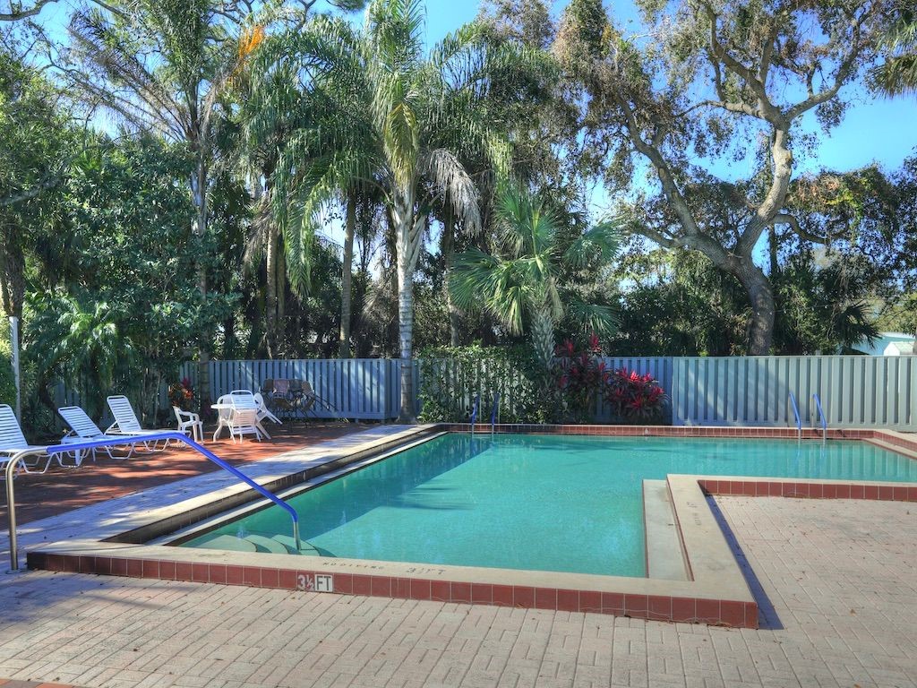 2150 Pine Creek Boulevard, Unit 202 Vero Beach, FL 32966 - Photo 29 of 31 a backyard of a house with table and chairs