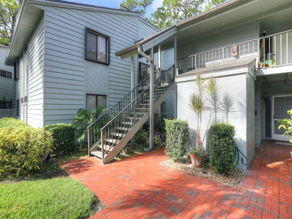 2150 Pine Creek Boulevard, Unit 202 Vero Beach, FL 32966 - Photo 3 of 31 a backyard of a house with plants and outdoor seating