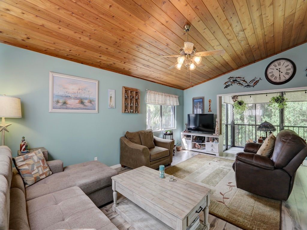 2150 Pine Creek Boulevard, Unit 202 Vero Beach, FL 32966 - Photo 7 of 31 a living room with furniture a clock and a large window