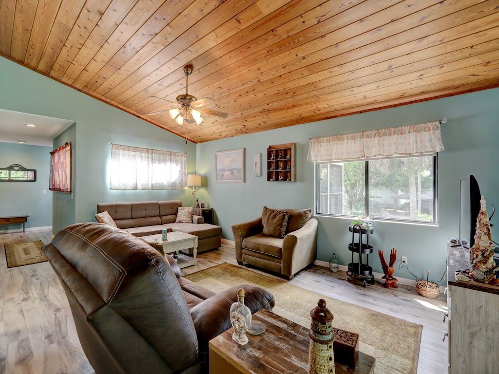 2150 Pine Creek Boulevard, Unit 202 Vero Beach, FL 32966 - Photo 8 of 31 a living room with furniture a chandelier fan and a window