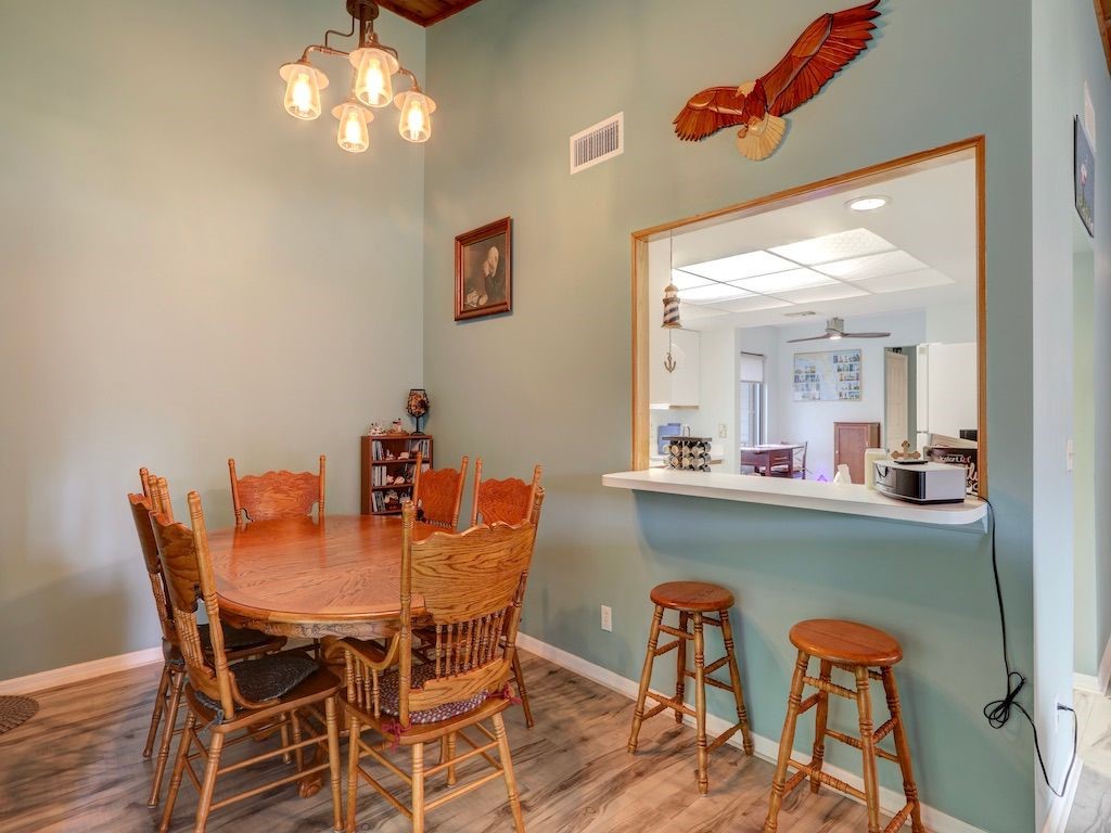 2150 Pine Creek Boulevard, Unit 202 Vero Beach, FL 32966 - Photo 10 of 31 a dining room with furniture and chandelier