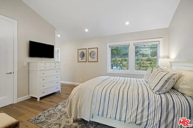 a bedroom with a bed and a flat screen tv