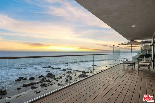 a kitchen with stainless steel appliances kitchen island granite countertop a dining table chairs and white cabinets