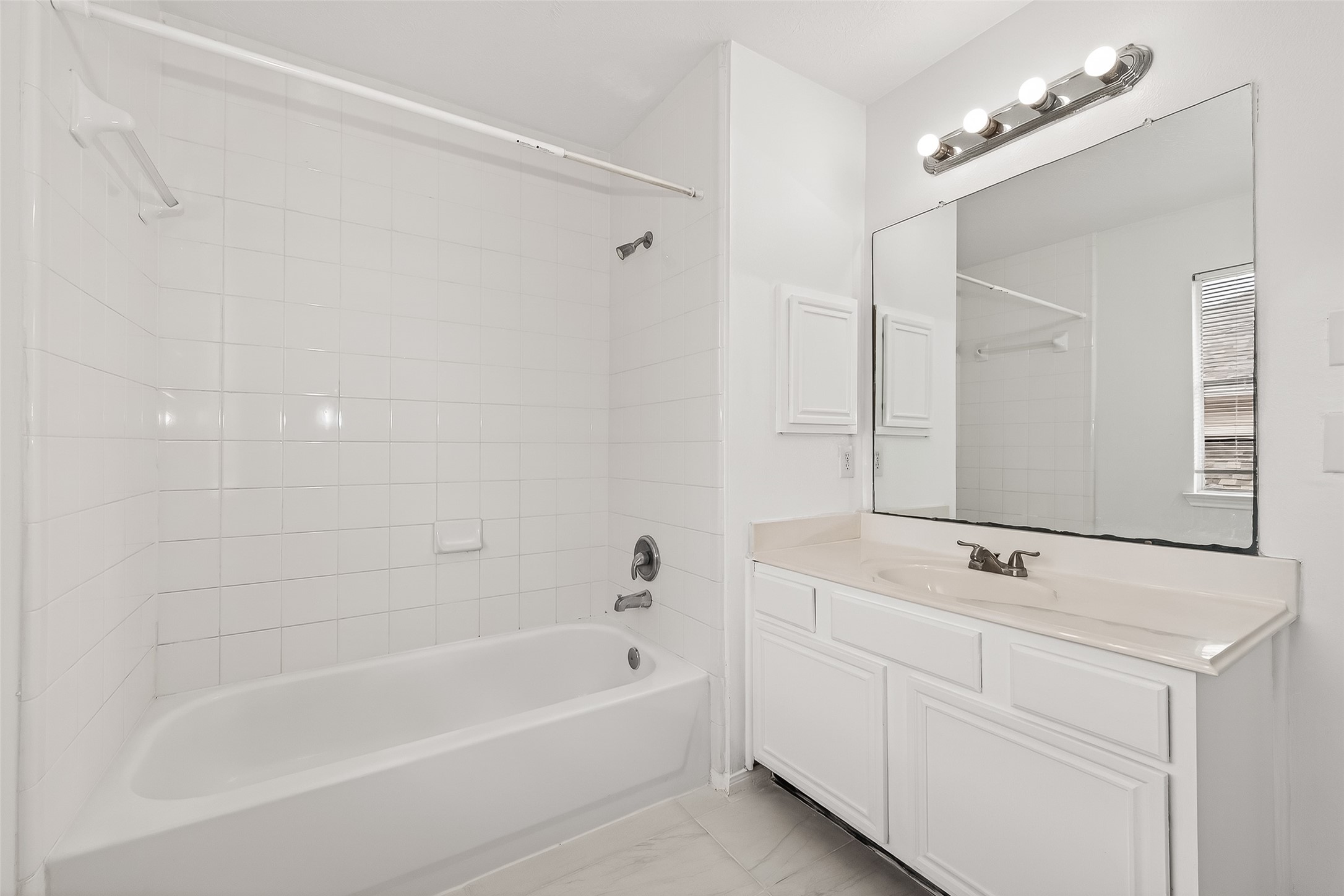 18807 Forest Deer Road Houston, TX 77084 - Photo 17 of 29 a bathroom with a bathtub a shower a sink and a mirror