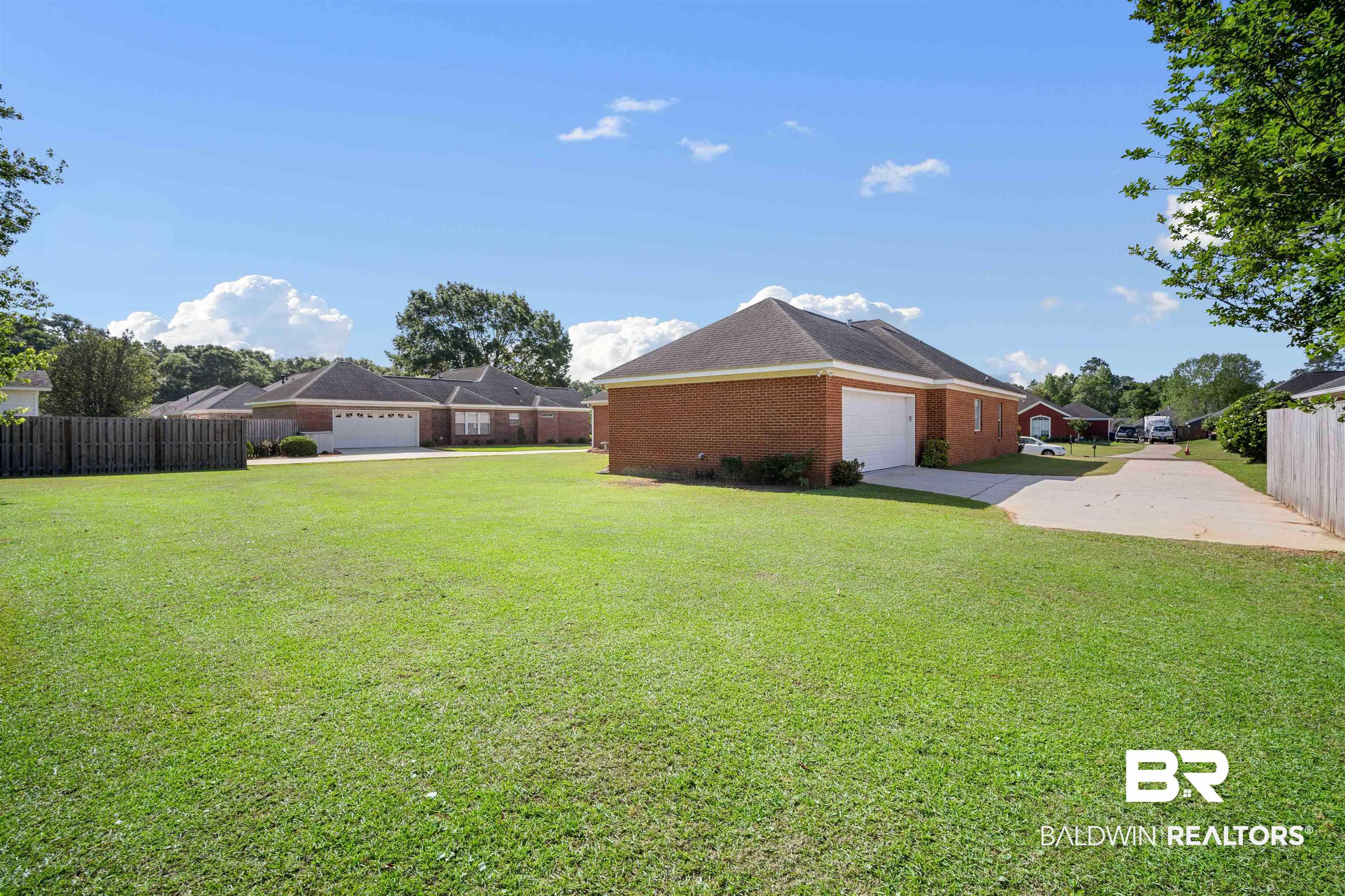 9552 White Castle Road Mobile, AL 36695 - Photo 31 of 31 View of yard with a garage, driveway, and partial fence