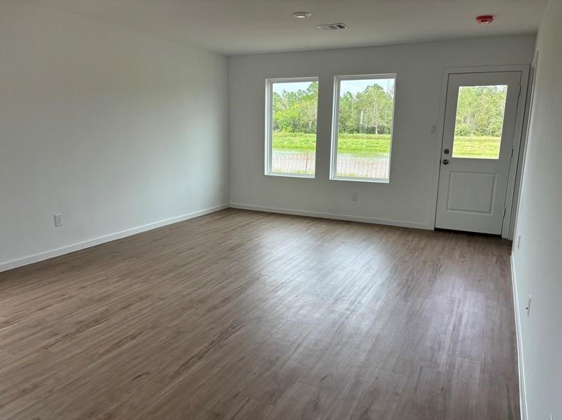 654 Maria Elena Way Cleveland, TX 77327 - Photo 6 of 23 a view of an empty room with wooden floor and a window