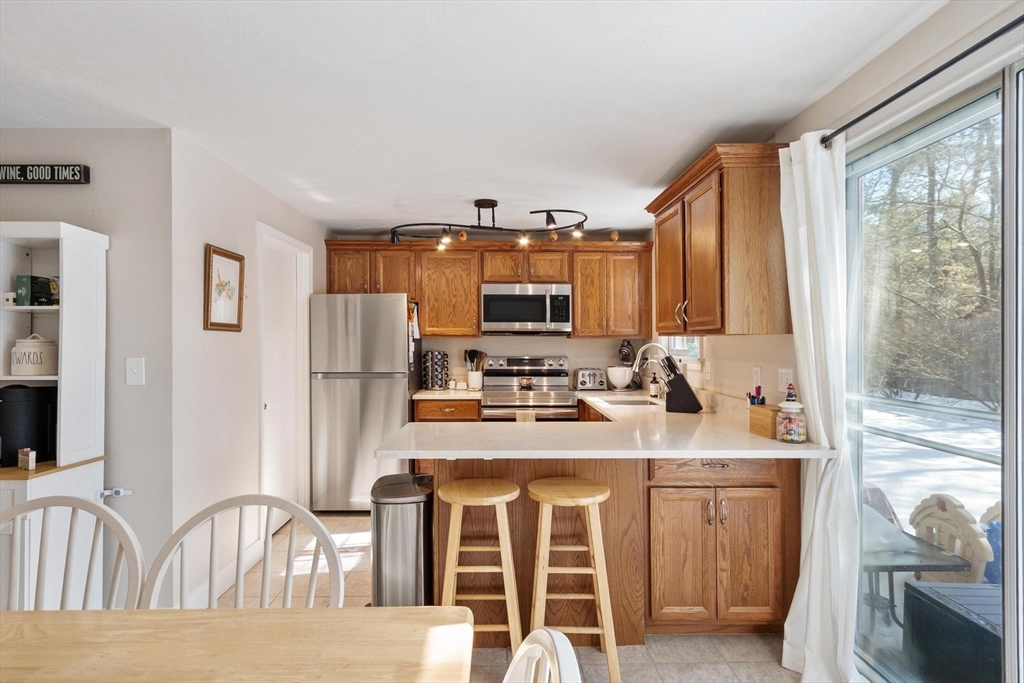 75 Sandy Pond Road, Unit 41 Ayer, MA 01432 - Photo 12 of 36 a kitchen with stainless steel appliances a stove a sink refrigerator and a view of living room