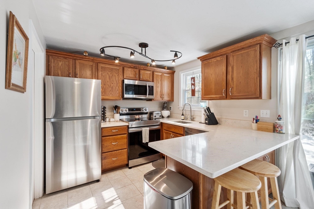 75 Sandy Pond Road, Unit 41 Ayer, MA 01432 - Photo 14 of 36 a kitchen with stainless steel appliances a stove refrigerator sink and microwave
