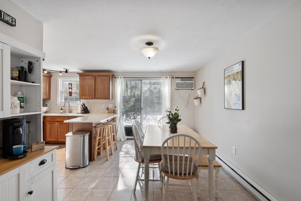 75 Sandy Pond Road, Unit 41 Ayer, MA 01432 - Photo 9 of 36 a kitchen with a table chairs and flat screen tv