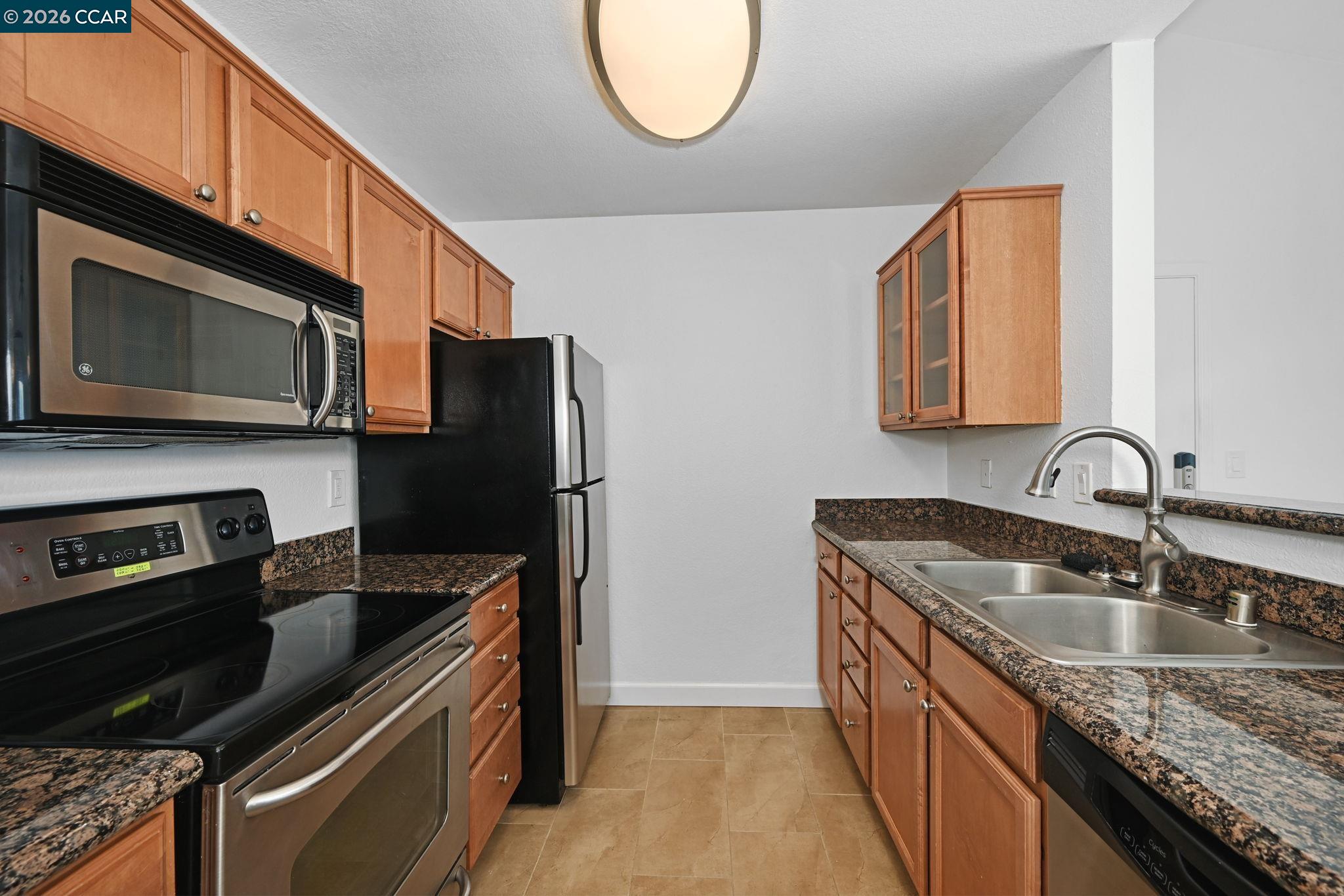 140 Reflections Drive, Unit 21 San Ramon, CA 94583 - Photo 10 of 34 a kitchen with stainless steel appliances granite countertop a sink stove and microwave