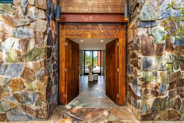 a view of a hallway with wooden floor and a dining space