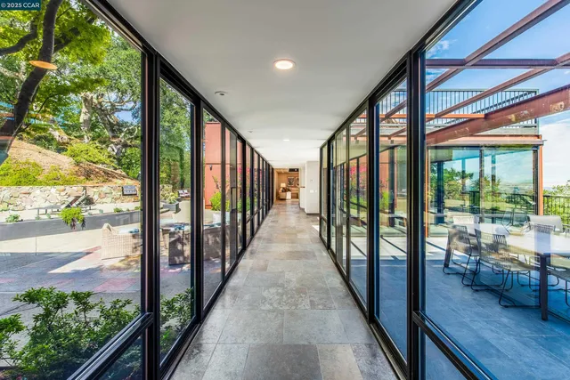 a view of a porch with wooden floor and floor to ceiling windows