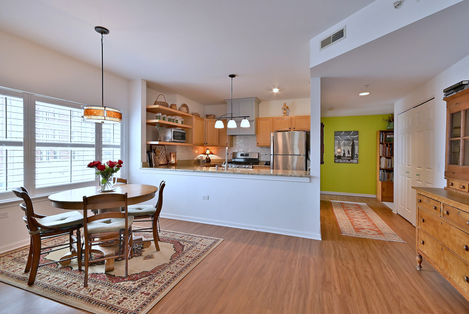 210 North Addison Avenue, Unit 301 Elmhurst, IL 60126 - Photo 14 of 30 a kitchen with stainless steel appliances granite countertop wooden floor dining table and chairs