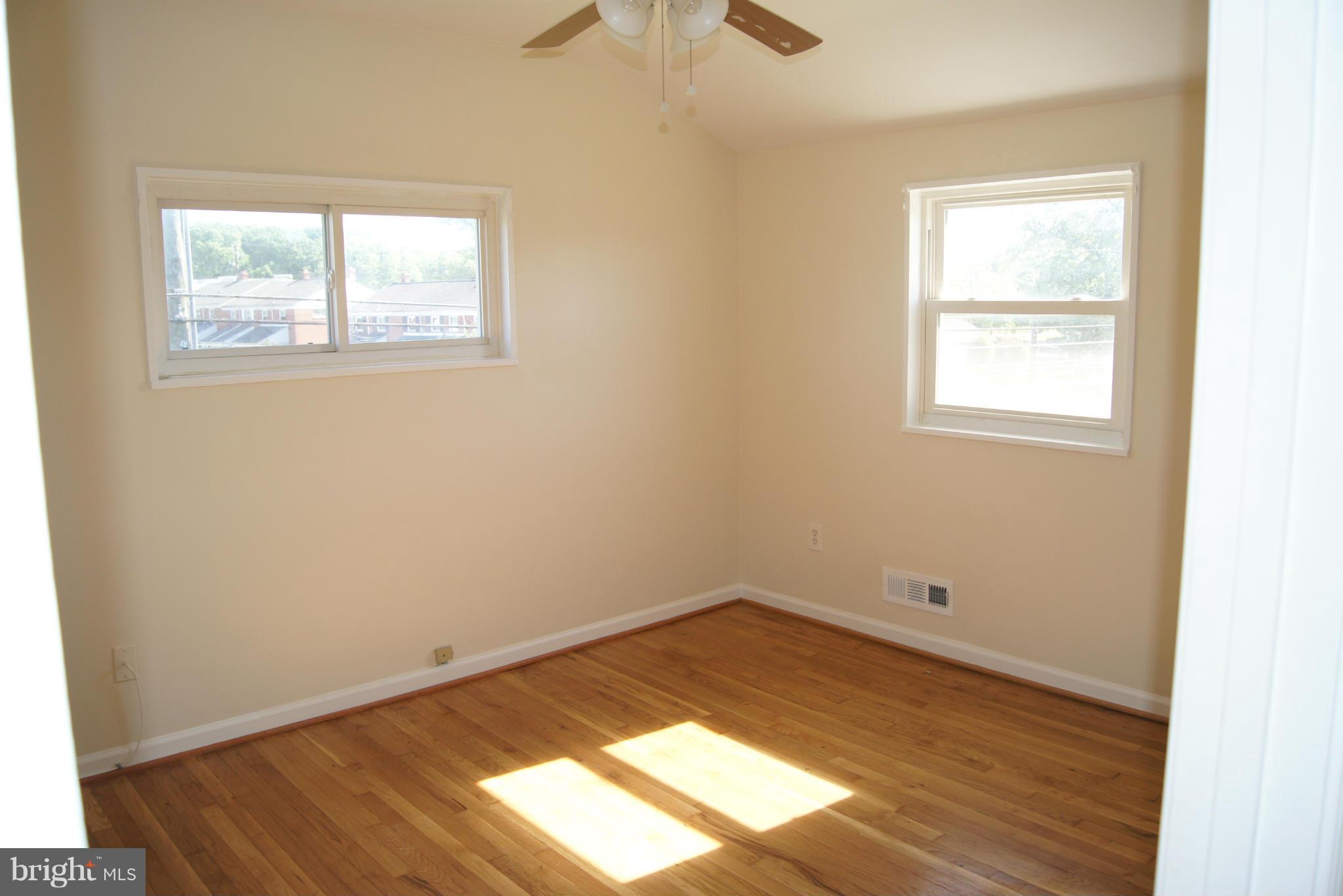 7954 Charlesmont Road Baltimore, MD 21222 - Photo 12 of 24 an empty room with wooden floor and windows