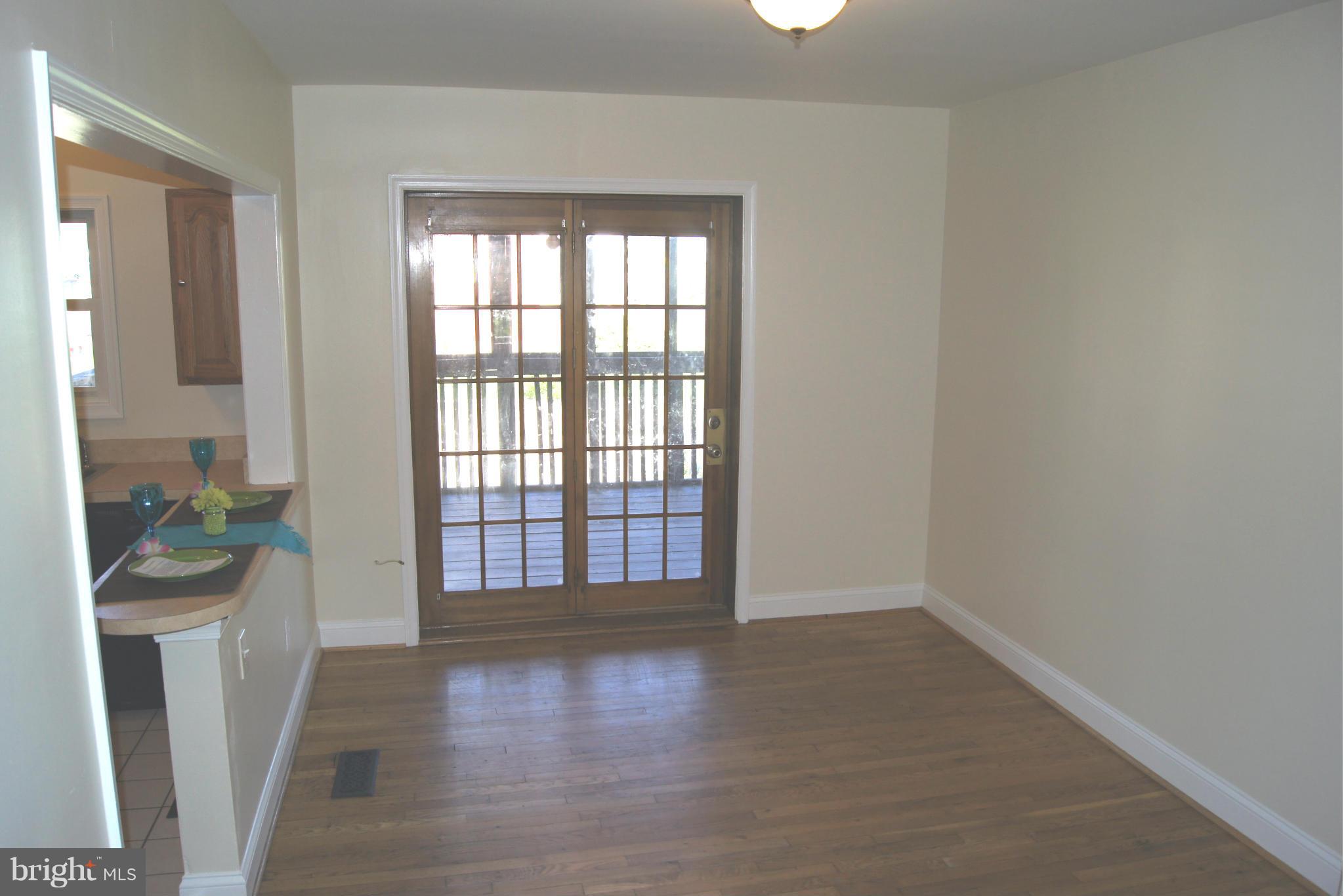 7954 Charlesmont Road Baltimore, MD 21222 - Photo 4 of 24 an empty room with wooden floor and a window