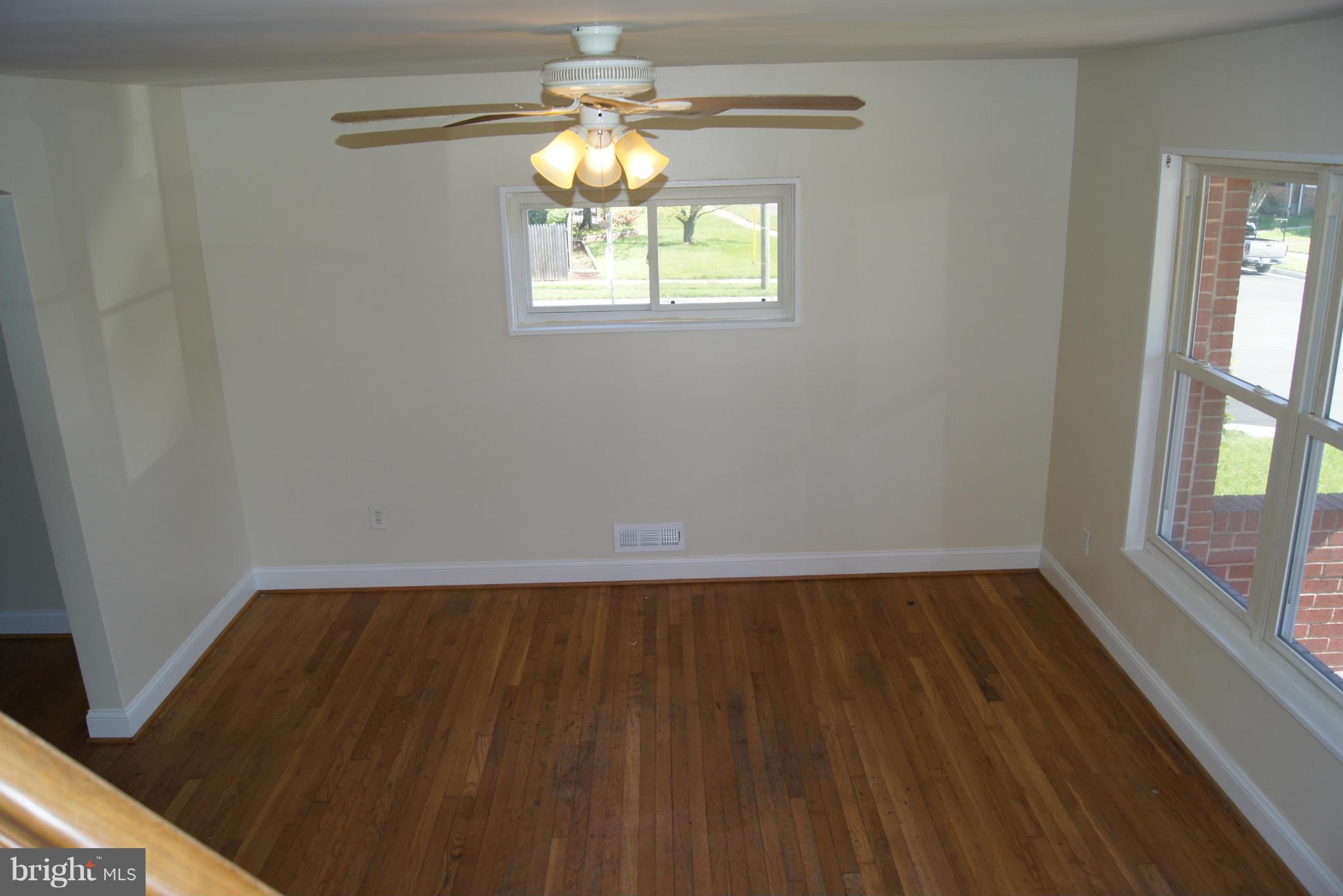 7954 Charlesmont Road Baltimore, MD 21222 - Photo 9 of 24 an empty room with wooden floor and windows