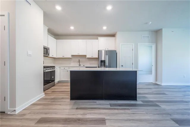 a view of kitchen with granite countertop cabinets and a sink