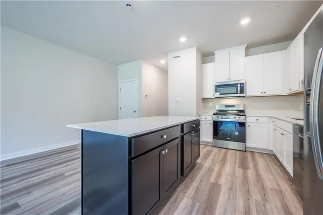 a kitchen with stainless steel appliances granite countertop a stove a sink and a refrigerator